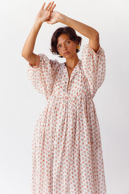Daughters of India Kyra Maxi Dress in Coral — studio arms raised showing V-neckline and billowed sleeves, block print cotton