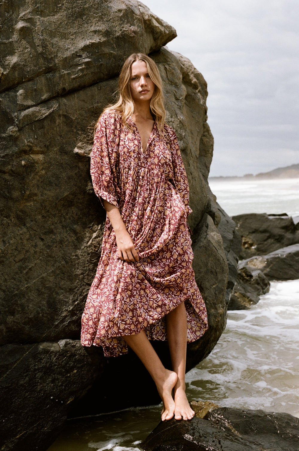 Daughters of India Kyra Midi Dress in Sumac — leaning against boulder at beach, screen print cotton