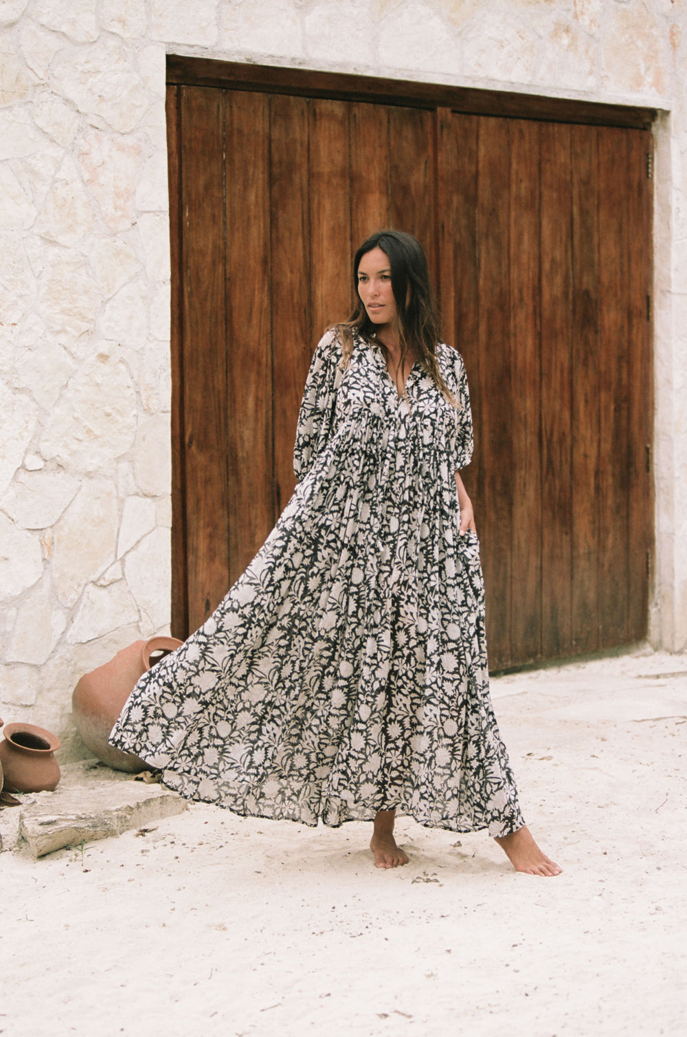 Daughters of India Kyra Maxi Dress in Pepper — full length walking by stone wall and wooden doors, hand screen print
